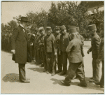 Paul Ruffy inspecting a line of young men in uniform.