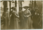 Women standing on a street corner.