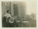 Woman reading a newspaper in the living room.