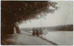 Two women near a boat on a canal, [Boat operator?]