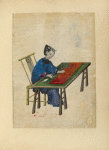Woman seated at a table, cutting cloth
