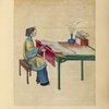Woman seated at a table with a large piece of cloth