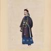 Man wearing long beaded necklace and tunic with design of large white bird