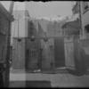 Backyard with laundry and outhouses and man (1905).