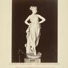Statue of woman wearing crown of flowers and gown.