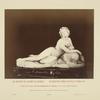 Statue of nude woman holding cup and laying on animal skin