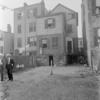 Tenement backyard with laundry & two men in suits