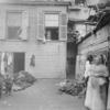 Tenement backyard with several women and children