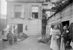 Tenement backyard with several women and children