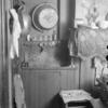 Interior of room: chair, shelf with comb, brush, lamp, bottles, clothing