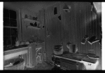Kitchen with stove, sink and utensils.