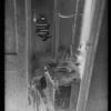 Toilet with newspaper on seat and pipes bound in rags