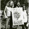 Man and woman with "All You Need is Love" sign