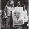Man and woman with "All You Need is Love" sign