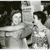 Isabel Miller hugging a librarian as Barbara Gittings looks on