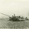 Farm workers and machinery in rice field