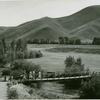 Golfers crossing path bridge