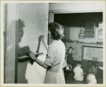 Woman writing on chalkboard