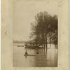 Men rowing boat through flood waters