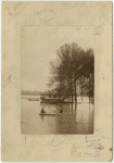 Men rowing boat through flood waters