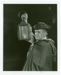 Man in colonial period attire holding lantern