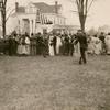 Wedding guests on lawn with man holding American flag