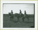 Three men mounted on horses in front of a group of soldiers, Camp Black, Long Island, New York