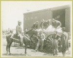 Men loading items into train car at Camp Black, Long Island, New York