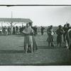 Man standing in front of a woman, soldiers standing with rifles on their shoulders, Camp Black, Long Island, New York