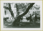 Two women approaching the entrance of an unidentified house