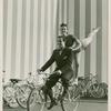 Amusements - American Jubilee - Scenes - Bicycle Number - Ray Middleton and Selma Hoffman on bicycle