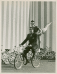 Amusements - American Jubilee - Scenes - Bicycle Number - Ray Middleton and Selma Hoffman on bicycle