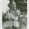Amusements - Performers and Personalities - Fairbanks, Douglas Sr. and Jr. - Douglas Fairbanks Jr. standing on camel held by Frank Buck