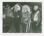 Amusements - Shows and Attractions - Wild West - Indian man putting headdress on Grover Whalen