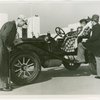 Automobiles - Ye Goode Olde Days - Man pumping tire while woman waits