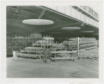 Benches stacked under overpass.