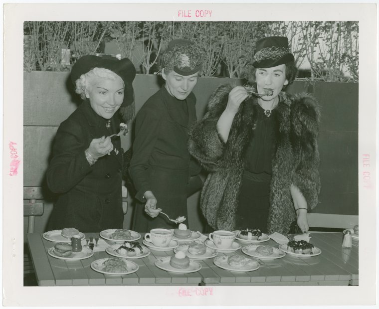 Three women tasting doughnuts