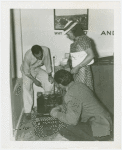 Electric Utilities - Electrified Farm - Woman and two men look at machine