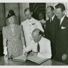 Fairgrounds - Visitors - Official signs guestbook with group looking on