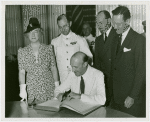 Fairgrounds - Visitors - Official signs guestbook with group looking on