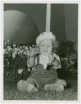 Fairgrounds - Visitors - Baby sitting in grass with Trylon and Persisphere in background