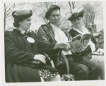 Fairgrounds - Visitors - Women and man on bench look at guidebook