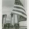 Flags - Men pulling down American flag outside of Australian Pavilion