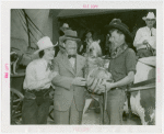 Florida Participation - Man who drove covered wagon from Florida presenting basket to Grover Whalen while Ruth Mix looks on
