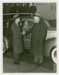 Ford - Ford, Edsel - Shaking hands with Harvey Gibson while James Rooney sits in 28 millionth Ford car