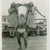 Strongman John Grimek holds up two girls
