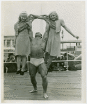 Strongman John Grimek holds up two girls