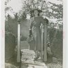 Gardens on Parade - Woman in hat standing at gate