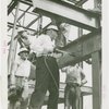 General Motors - Knudsen, William S. - Putting rivet into steel framework while workers watch