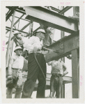 General Motors - Knudsen, William S. - Putting rivet into steel framework while workers watch